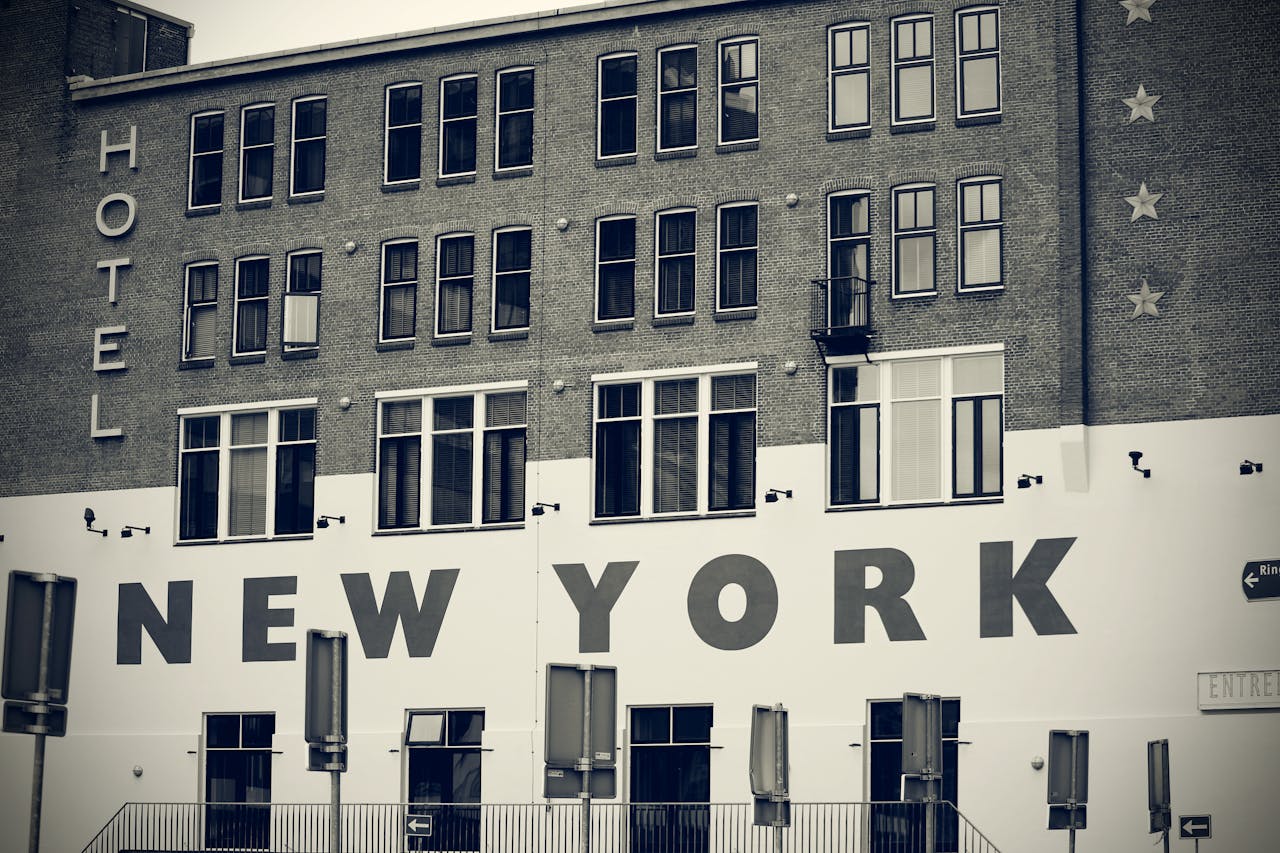 Black and white photo of a hotel facade with New York signage, showcasing urban architecture.
